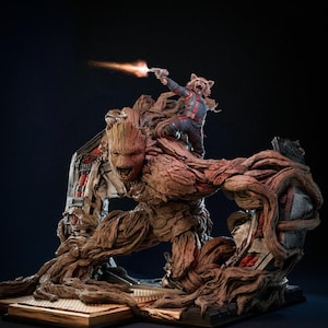 Puede incluir: Una estatua detallada que representa a Groot, un humanoide con forma de árbol, con Rocket, una criatura parecida a un mapache, disparando un arma. La estatua es predominantemente marrón con acentos rojos y grises, sobre un fondo oscuro. Las figuras están posadas dinámicamente.