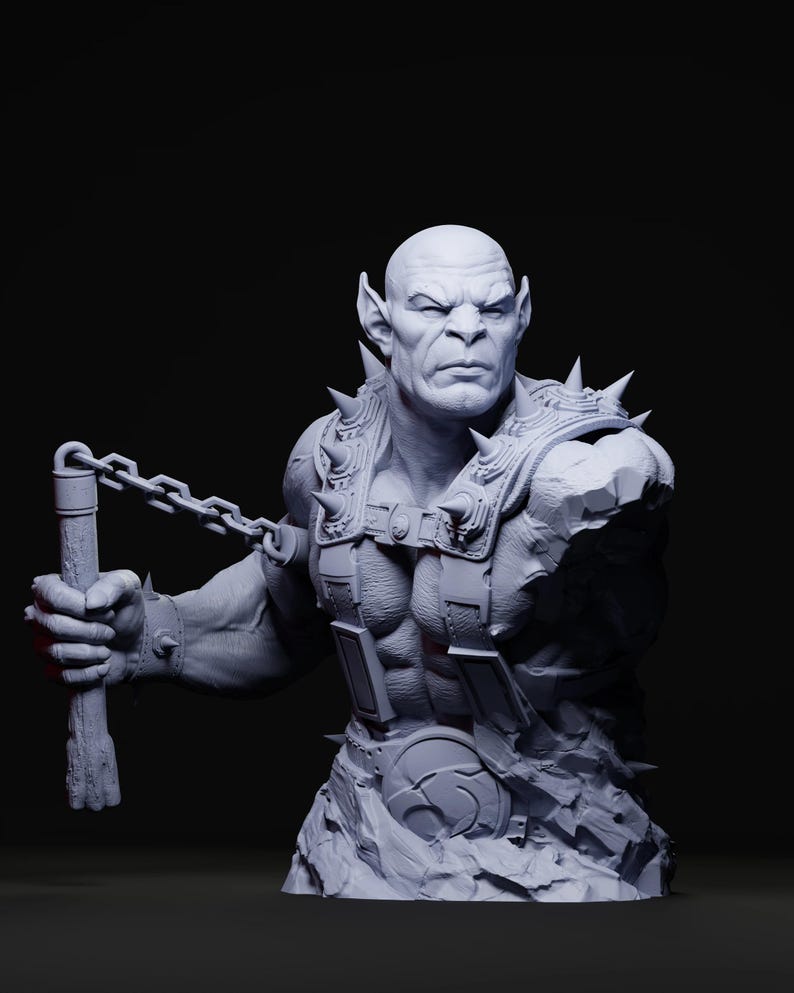 May include: A gray bust of a muscular, bald humanoid figure with pointed ears and a stern expression. The figure wears spiked armor and holds a chain weapon. The sculpture has a detailed, textured surface.
