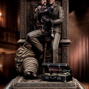 May include: A detailed sculpture depicts a man holding a puppet with a machine gun. The man wears a checkered suit and glasses. The puppet is dressed in a suit and fedora. A suitcase filled with money and dynamite sits nearby.