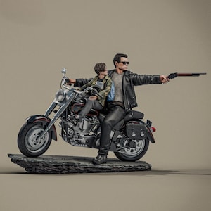 May include: A detailed figurine depicts two figures on a motorcycle. One figure, in a leather jacket, holds a shotgun. The motorcycle is black and silver, mounted on a stone base. The other figure is wearing a camouflage jacket.