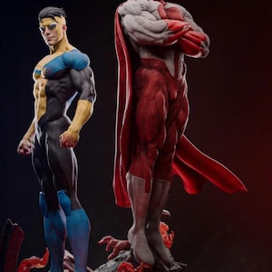 May include: Two superhero statues. One is in a black and blue suit with yellow skin and hair. The other is in a red and white suit with a red cape. Both are standing on a rocky base with red flames.