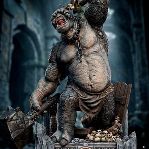 Puede incluir: Estatua detallada que representa un gran trol musculoso con un garrote con púas, encadenado alrededor del cuello. Un elfo con un arco está encima del trol. La base presenta calaveras y el texto "LORD OF THE RINGS".