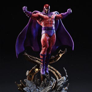 Puede incluir: Figura detallada de Magneto, un personaje de cómic, en una pose dinámica. La figura está vestida con un traje rojo y morado con casco, capa y botas. La estatua está montada sobre una base rocosa con detalles dorados, sobre un fondo oscuro.