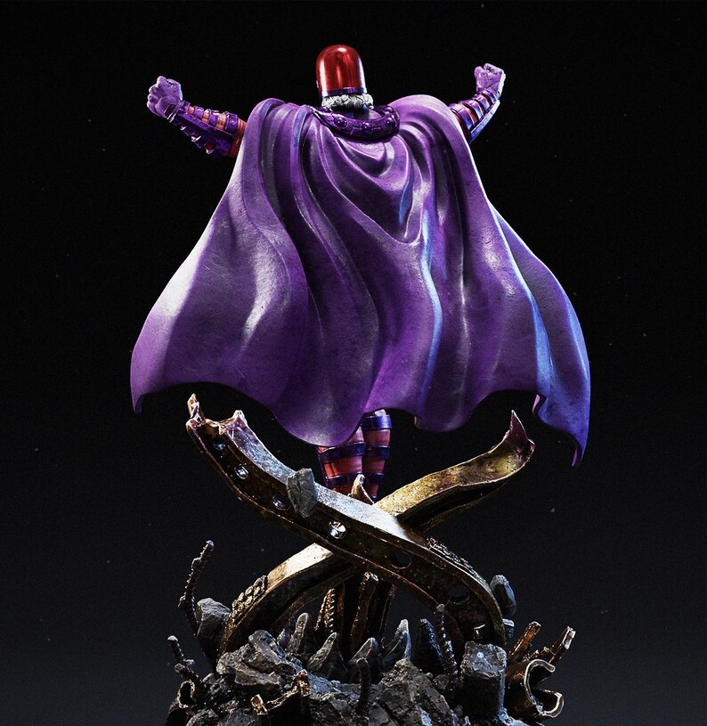 May include: A statue of a character in a purple cape and helmet, arms raised. The figure stands on a detailed base with a metallic X-shaped design. The cape is a deep purple, and the helmet is red.