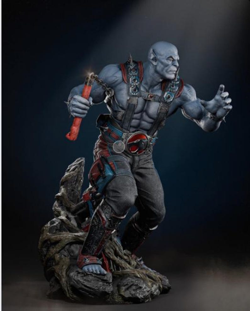 May include: A detailed statue of a muscular, blue-skinned humanoid figure holding a red weapon with a chain. The figure is wearing a harness, belt, and pants with red and blue accents. The statue is posed on a rocky base.