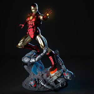 May include: A dynamic statue of Iron Man in a red and gold suit, mid-action, with a glowing hand. He is posed above a defeated, gray robotic figure. The base is a rocky terrain with metallic debris, showcasing a battle scene.