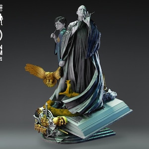 Pode incluir: Estátua de resina detalhada com personagens da série Harry Potter. A estátua retrata Voldemort e Harry Potter, com uma coruja e uma cobra. A base é um livro com as palavras "Harry Potter". A estátua é em escala 1/6.