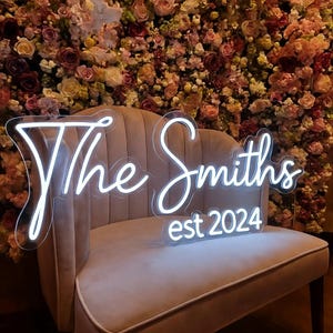 Puede incluir: Un letrero de madera rústica con el texto "Welcome to our home" en letras blancas. El letrero presenta un acabado envejecido y un diseño simple y acogedor, perfecto para la decoración de la entrada.