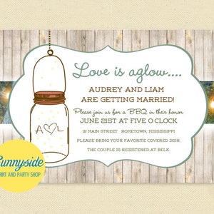 Op de afbeelding: Een rustieke huwelijksuitnodiging met een glazen pot gevuld met vuurvliegjes en de tekst "Love is aglow... Audrey and Liam are getting married!"  U bent van harte welkom voor een BBQ ter ere van hun huwelijk op 21 juni om 17:00 uur. 12 Main Street, Hometown, Mississippi. Breng gerust uw favoriete gerecht mee. Het paar is geregistreerd bij Belk.