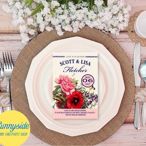 May include: A wedding invitation with a floral design. The invitation is for Scott & Lisa Fletcher, and the wedding date is May 06, 2017. The invitation includes a quote by Ralph Waldo Emerson: "Love is like wildflowers, it is often found in the most unlikely places."