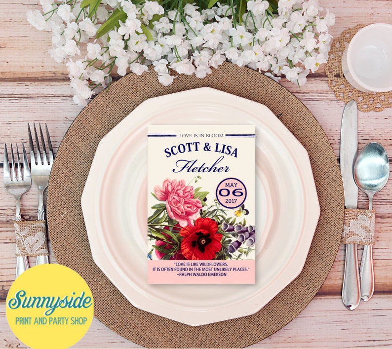 May include: A wedding invitation with a floral design. The invitation is for Scott & Lisa Fletcher, and the wedding date is May 06, 2017. The invitation includes a quote by Ralph Waldo Emerson: "Love is like wildflowers, it is often found in the most unlikely places."