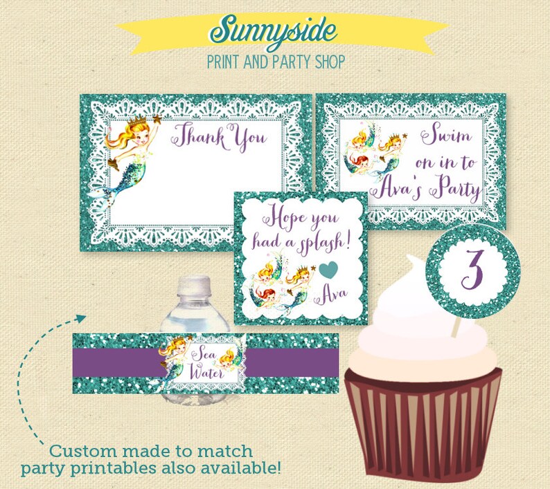 Op de afbeelding: Een set bedrukte feestversieringen met een zeemeermin-thema. De versieringen omvatten een bedankkaart, een bord met de tekst "Swim on in to Ava's Party", een cupcaketopper met het nummer 3 en een waterfleslabel met de tekst "Sea Water".