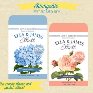 May include: Two wedding favor seed packets with a floral design. The left packet features a blue hydrangea and the right packet features a pink rose. Both packets have the text "Love is in bloom" and "Ella & James Elliott" with the wedding date "March 23, 2013".