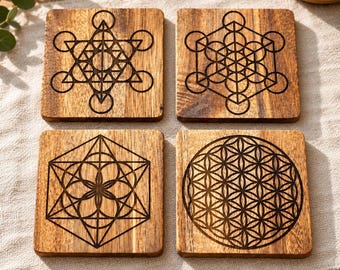 May include: A set of four square wooden coasters featuring dark laser-engraved geometric patterns. Each coaster displays a distinct sacred geometry design, including the Metatron's Cube, the Fruit of Life, the Seed of Life, and the Flower of Life.
