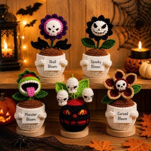 Puede incluir: Cinco plantas de ganchillo en macetas con temas de Halloween. Cada maceta blanca tiene una etiqueta: Skull Bloom, Spooky Bloom, Monster Bloom y Cursed Bloom. Las plantas incluyen flores con calaveras, un monstruo verde y una criatura negra.