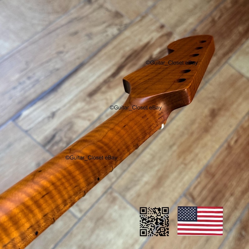 Puede incluir: Primer plano del m&aacute;stil y pala de una guitarra, hechos de arce veteado. La madera tiene un tono &aacute;mbar c&aacute;lido con patrones de vetas prominentes. La pala presenta seis agujeros para clavijas. La imagen incluye un c&oacute;digo QR y una bandera estadounidense.