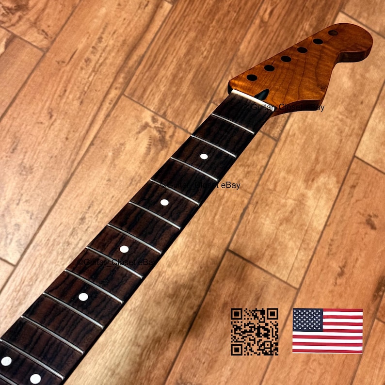 May include: A guitar neck featuring a dark, wood-grained fretboard with white circular position markers and metal frets. The headstock is finished in a warm, amber-toned wood grain and includes six pre-drilled holes for tuning pegs.