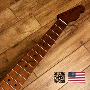 K&ouml;nnte beinhalten: Ein neuer, unfertiger Gitarrenhals mit einer dunkelbraunen Kopfplatte und Griffbrett. Der Hals hat wei&szlig;e Bundmarkierungen und eine nat&uuml;rliche Holzoberfl&auml;che. Das Bild enth&auml;lt einen QR-Code und die amerikanische Flagge.