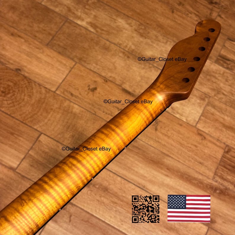 May include: A close-up of a guitar neck with a flamed maple finish. The neck has a natural wood grain pattern with a warm, golden-brown color. The headstock has pre-drilled holes for tuning pegs. The text "Guitar_Closet eBay" is visible.