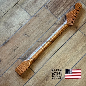 May include: A guitar neck crafted from figured maple, displaying a natural wood grain pattern in a light brown hue. The headstock features six tuning peg holes. The image also includes a QR code and the American flag.