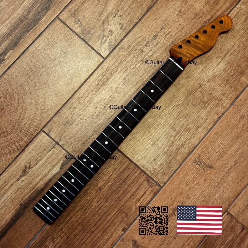 Puede incluir: M&aacute;stil de guitarra con diapas&oacute;n oscuro e incrustaciones de puntos blancos. El clavijero es de madera m&aacute;s clara con acabado natural. El m&aacute;stil est&aacute; inclinado sobre una superficie de madera. La bandera americana est&aacute; en la esquina inferior derecha.