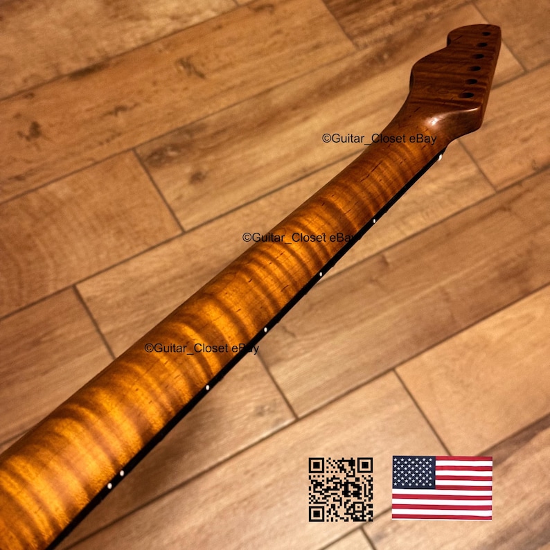 May include: A guitar neck with a flamed maple finish. The neck is a warm brown color with a striped pattern. The headstock has tuning peg holes. The image includes a QR code and an American flag.