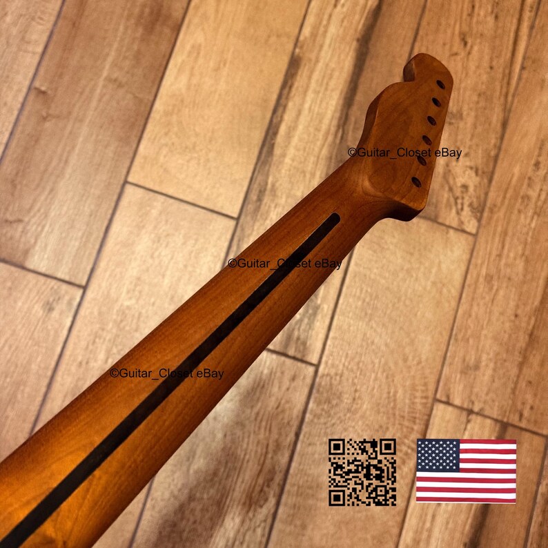 May include: A wooden guitar neck with a dark brown finish and a black stripe down the center. The headstock has six tuning peg holes. The image includes a QR code and a small American flag.