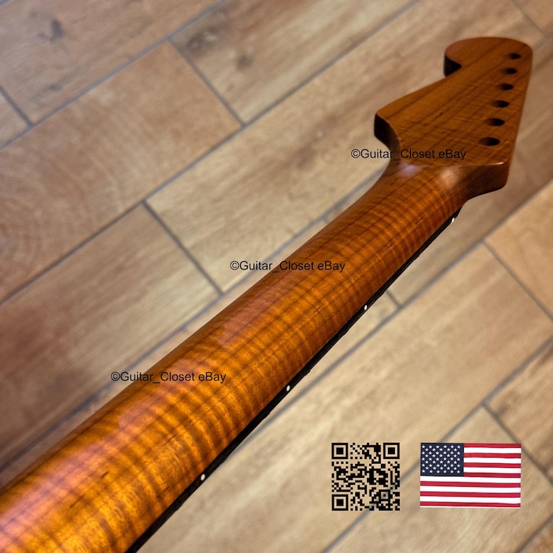 May include: A close-up of a guitar neck made of figured wood, showcasing a rich, amber color and intricate grain patterns. The headstock features tuning peg holes. The image includes the text "Guitar Closet eBay" and a QR code and American flag.