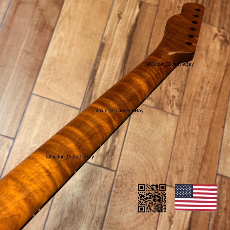 May include: A guitar neck with a flamed maple finish. The neck is a warm amber color with dark brown figuring. The headstock has pre-drilled holes for tuning pegs. The image includes a QR code and a small American flag.