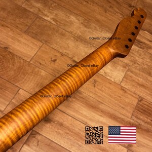 May include: A guitar neck with a flamed maple finish. The neck is a warm amber color with dark brown grain patterns. The headstock has six tuning peg holes. The image includes a QR code and a small American flag.