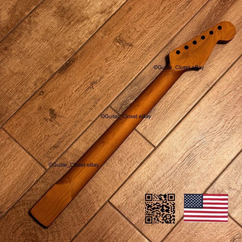 K&ouml;nnte beinhalten: Ein h&ouml;lzerner Gitarrenhals mit nat&uuml;rlichem Finish. Der Hals hat eine Kopfplatte mit sechs Stimmwirbell&ouml;chern und einen langen, schlanken Hals. Der Hintergrund ist ein Holzboden. Das Bild enth&auml;lt auch einen QR-Code und eine amerikanische Flagge.