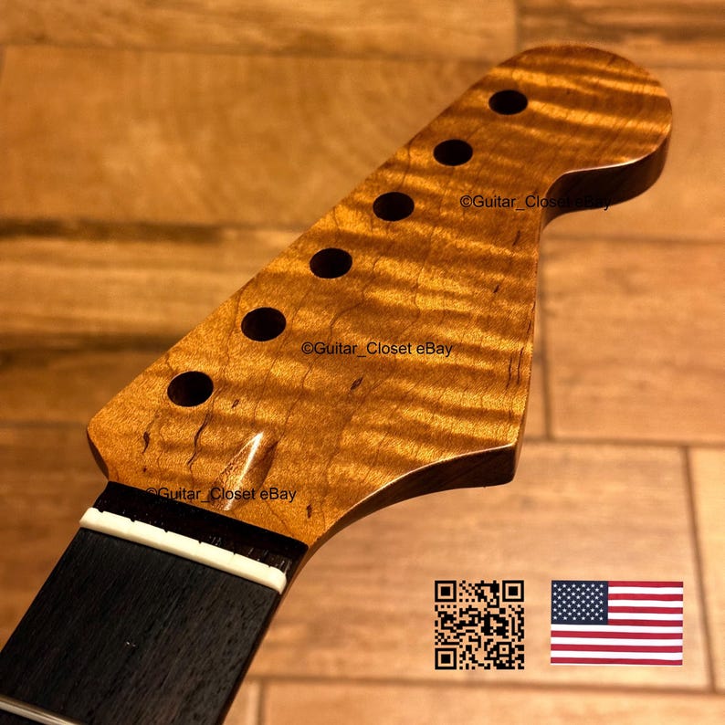 Op de afbeelding: Een gitaarkop gemaakt van amberkleurig gevlamd esdoornhout met een opvallend golvend nerfpatroon. De kop bevat zes ronde gaten voor stemmechanieken, een donkere toets en een witte topkam. De tekst Guitar_Closet eBay is zichtbaar.