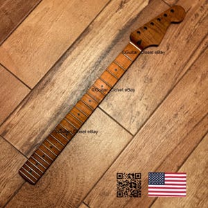 Op de afbeelding: Een gitaarhals met een natuurlijke houten afwerking. De hals heeft een kop met stemgaten en een toets met ingelegde positiemarkeringen. De afbeelding bevat de tekst "Guitar Closet eBay", een QR-code en een Amerikaanse vlag.