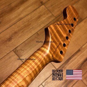 K&ouml;nnte beinhalten: Ein Gitarrenhals mit Kopfplatte in nat&uuml;rlicher Holzmaserung und sechs L&ouml;chern f&uuml;r Stimmmechaniken. Das Holz weist ein ausgepr&auml;gtes Tigerstreifenmuster &uuml;ber die gesamte L&auml;nge von Hals und Kopfplatte auf. Der Text Guitar_Closet eBay ist sichtbar.