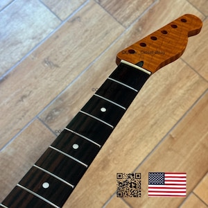 May include: A guitar neck with a flamed maple headstock and a dark rosewood fretboard. The headstock has six tuning peg holes. The fretboard has white dot inlays and metal frets. The neck is unfinished and ready for installation.