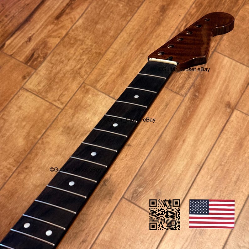 May include: A guitar neck with a dark brown headstock and a black fretboard. The fretboard has white dot inlays and silver frets. The headstock has tuning peg holes. The text "Guitar Closet eBay" is visible. An American flag is in the bottom right corner.