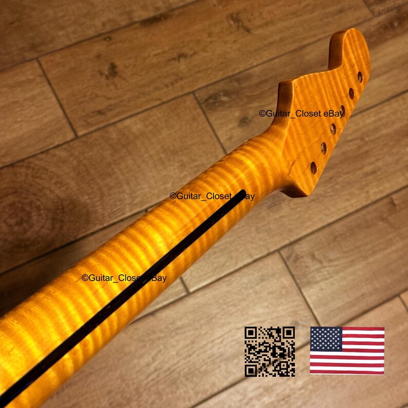 May include: A guitar neck with a flamed maple finish. The neck has a dark stripe down the center and tuning peg holes at the headstock. The image includes a QR code and a small American flag.
