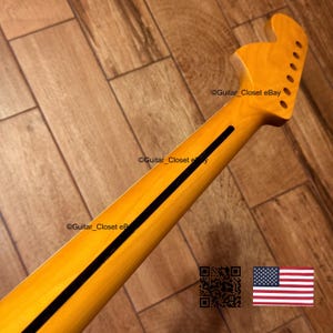 K&ouml;nnte beinhalten: Gitarrenhals mit nat&uuml;rlicher Holzoberfl&auml;che, mit einem schwarzen Streifen in der Mitte. Die Kopfplatte hat sechs L&ouml;cher f&uuml;r die Stimmwirbel. Das Bild enth&auml;lt den Text "Guitar_Closet eBay" und eine kleine amerikanische Flagge.