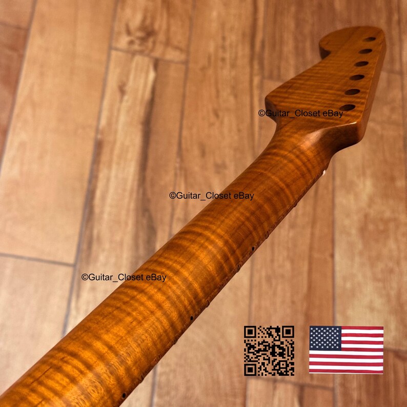 May include: A close-up of a guitar neck made of figured maple wood. The neck has a natural finish, with visible wood grain patterns. The headstock features tuning peg holes. The image includes a QR code and the American flag.