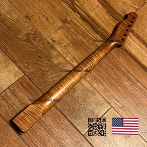 Pu&ograve; includere: Un manico per chitarra in acero fiammato marrone con un evidente motivo a venature tigrate, una paletta con sei fori per le meccaniche e un tallone. Il testo Guitar Closet eBay &egrave; visibile sul legno, insieme a un codice QR e una bandiera USA.