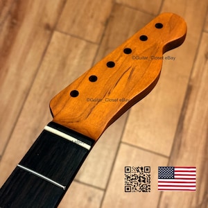 Op de afbeelding: Gitaarhals met een natuurlijke houten afwerking, zwarte fretmarkeringen en een zwarte toets. De kop heeft een klassieke vorm. De afbeelding bevat een QR-code en de Amerikaanse vlag.
