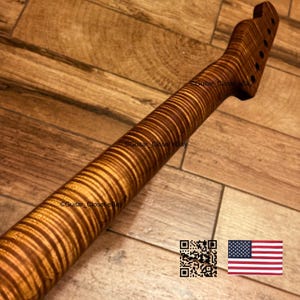 Pu&ograve; includere: Un manico di chitarra caratterizzato da un motivo a venature di legno d'acero fiammato con strisce di tigre e una calda finitura ambrata. La paletta include sei fori preforati per le meccaniche. Il testo Guitar_Closet eBay &egrave; visibile.