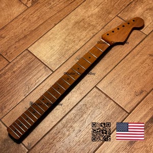 Puede incluir: Un m&aacute;stil de guitarra de madera marr&oacute;n claro con un clavijero de seis orificios, un diapas&oacute;n con trastes plateados y marcadores de posici&oacute;n circulares oscuros. El texto Guitar_CloseBay es visible, junto a un c&oacute;digo QR y una bandera de EE. UU.