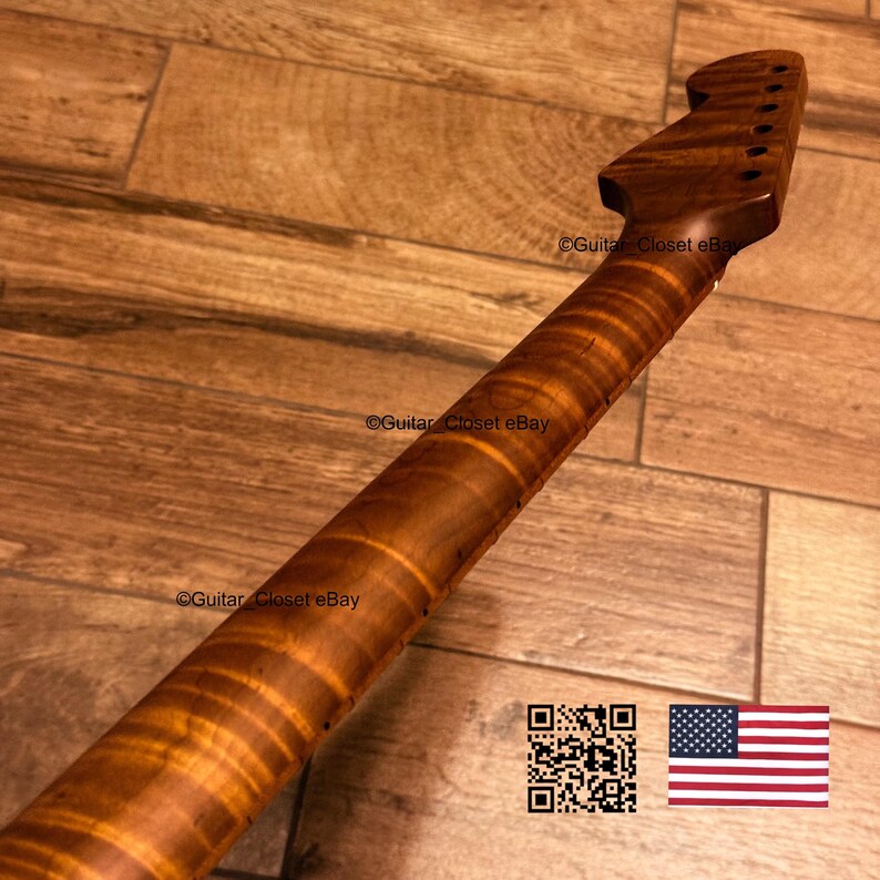 May include: A guitar neck made of brown wood with a prominent tiger stripe flame pattern. The headstock features six circular tuning peg holes arranged in a row. The text Guitar Closet eBay is visible on the neck and headstock, with a QR code and a US flag.