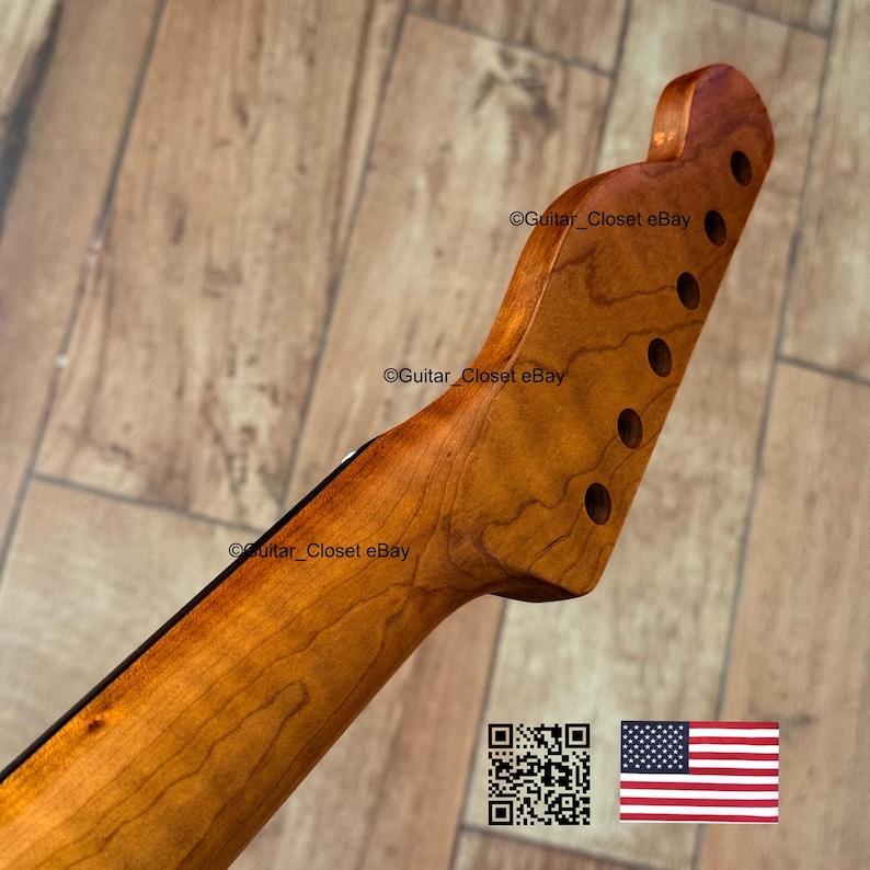 以下が含まれることがあります： 自然な仕上がりの木製ギターネック。ヘッドストックには6つのペグ穴があります。ネックは明るい茶色で、より濃い木目模様があります。画像にはQRコードとアメリカ国旗が含まれています。