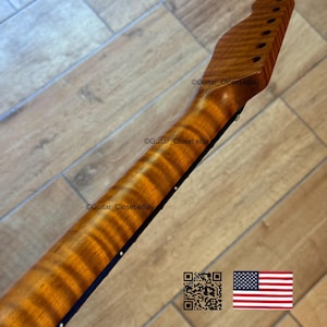 May include: A close-up of a guitar neck with a flamed maple finish. The wood grain has a prominent, wavy pattern. The headstock has pre-drilled holes for tuning pegs. The image includes a QR code and an American flag.