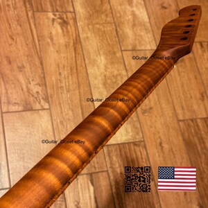 May include: A close-up of a guitar neck with a flamed maple finish. The neck is a warm brown color with a striped pattern. The headstock has pre-drilled holes for tuning pegs. The image includes the text "Guitar Closet eBay".