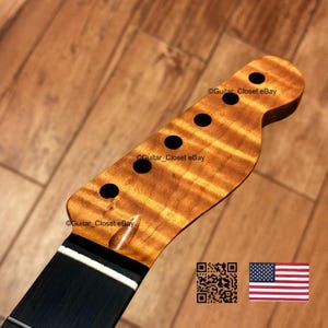 May include: A guitar headstock featuring a natural amber-toned flamed maple wood grain pattern with six circular tuning peg holes. The headstock includes a white nut and a dark fretboard. Text reads Guitar_Closet eBay with a QR code and US flag.