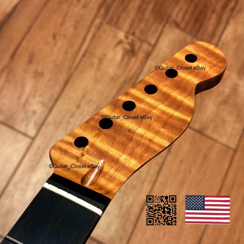 May include: A guitar headstock featuring a natural amber-toned flamed maple wood grain pattern with six circular tuning peg holes. The headstock includes a white nut and a dark fretboard. Text reads Guitar_Closet eBay with a QR code and US flag.
