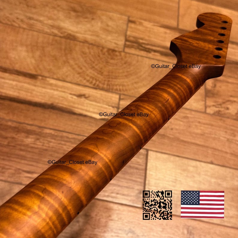 May include: A guitar neck made of brown wood with a prominent tiger-stripe flame maple grain pattern. The headstock features six tuner holes arranged in a row. The text Guitar_Closet eBay is visible on the neck and headstock, with a QR code and a US flag.